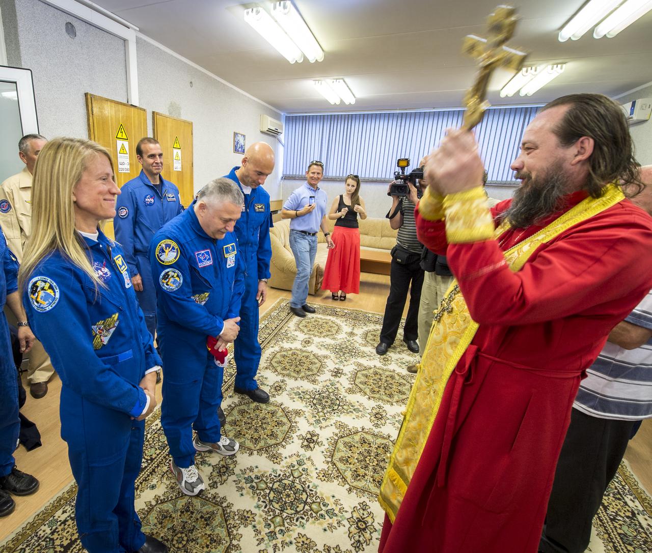 Expedition 36/37 Flight Engineer Karen Nyberg of NASA, left, Soyuz Commander Fyodor Yurchikhin of the Russian Federal Space Agency (Roscosmos), center, and Flight Engineer Luca Parmitano of the European Space Agency, receive a traditional blessing from an Orthodox Priest prior to the three crew members departing the Cosmonaut Hotel for suit up and launch onboard a Soyuz to the International Space Station, Tuesday, May 28, 2013, Baikonur Kazakhstan. The crew's Soyuz rocket is scheduled to launch at 2:31a.m., Wednesday May 29, Kazakh time. Yurchikhin, Nyberg, and, Parmitano, will remain aboard the station until mid-November. Photo credit: (NASA/Bill Ingalls)