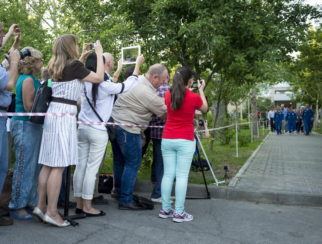 Family, friends and colleagues watch and photograph Expedition 36/37 Soyuz Commander Fyodor Yurchikhin of the Russian Federal Space Agency (Roscosmos), Flight Engineers; Karen Nyberg of NASA, and Luca Parmitano of the European Space Agency as they depart the Cosmonaut Hotel, Tuesday, May 28, 2013, in Baikonur, Kazakhstan. Yurichikin, Nyberg, Parmitano were departing the hotel in preparation for their launch on a Soyuz rocket to the International Space Station (ISS) on Wednesday May 29, Kazakh time. Photo credit: (NASA/Bill Ingalls)