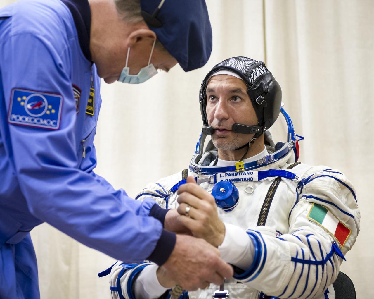 Expedition 36 European Space Agency Flight Engineer Luca Parmitano is helped into his Russian Sokol suit as he and fellow crewmates, Soyuz Commander Fyodor Yurchikhin and NASA Flight Engineer Karen Nyberg prepare for their Soyuz launch to the International Space Station, Tuesday, May 28, 2013, in Baikonur, Kazakhstan. Launch of the Soyuz rocket will send Parmitano, Yurchikhin and Nyberg on a five and a half month mission aboard the International Space Station. Photo Credit: (NASA/GCTC/Andrey Shelepin)