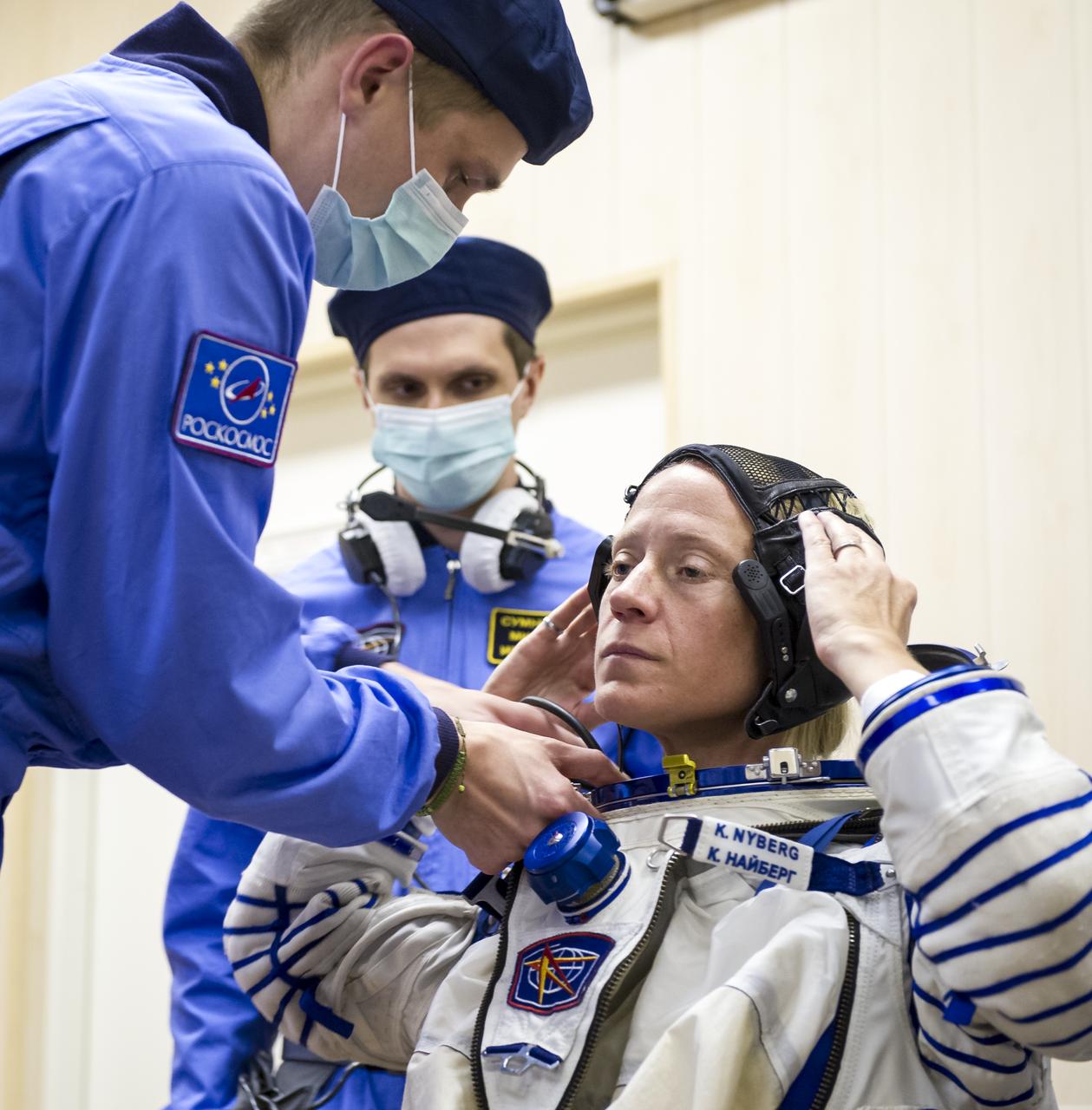 Expedition 36 NASA Flight Engineer Karen Nyberg is helped into her Russian Sokol suit as she and fellow crewmates, Soyuz Commander Fyodor Yurchikhin and European Space Agency Flight Engineer Luca Parmitano prepare for their Soyuz launch to the International Space Station, Tuesday, May 28, 2013, in Baikonur, Kazakhstan. Launch of the Soyuz rocket will send Nyberg, Yurchikhin and Parmitano on a five and a half month mission aboard the International Space Station.  Photo Credit: (NASA/GCTC/Andrey Shelepin)