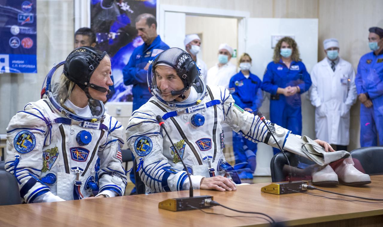 Expedition 36 NASA Flight Engineer Karen Nyberg, left, and European Space Agency astronaut Luca Parmitano share a word after donning their Russian Sokol suits in preparation for their launch aboard the Soyuz rocket, Tuesday, May 28, 2013, at the Baikonur Cosmodrome in Kazakhstan. Launch of the Soyuz rocket will send Nyberg, Parmitano and Soyuz Commander Fyodor Yurchikhin on a five and a half-month mission aboard the International Space Station. Photo Credit: (NASA/Bill Ingalls)