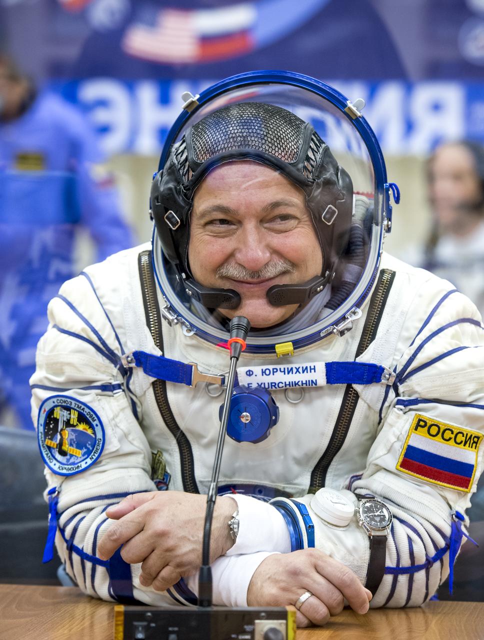Expedition 36 Soyuz Commander Fyodor Yurchikhin is seen talking to family members after donning his Russian Sokol suit in preparation for his launch aboard the Soyuz rocket, Tuesday, May 28, 2013, at the Baikonur Cosmodrome in Kazakhstan.  Launch of the Soyuz rocket will send Yurchikhin, Flight Engineer Karen Nyberg and European Space Agency Flight Engineer Luca Parmitano on a five and a half-month mission aboard the International Space Station.  Photo Credit: (NASA/Bill Ingalls)
