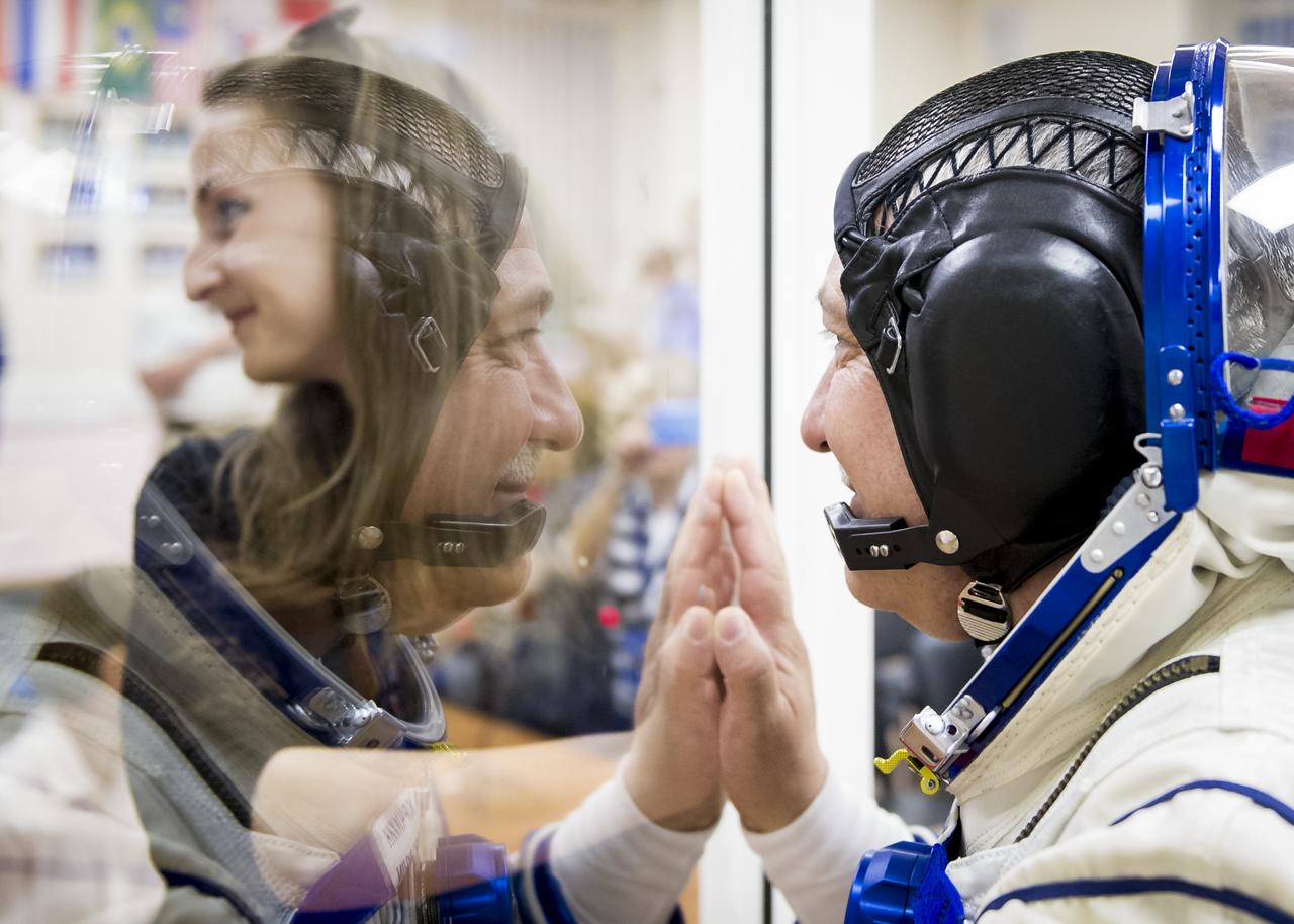 Expedition 36 Soyuz Commander Fyodor Yurchikhin is seen talking to family members after donning his Russian Sokol suit in preparation for his launch aboard the Soyuz rocket, Tuesday, May 28, 2013, at the Baikonur Cosmodrome in Kazakhstan.  Launch of the Soyuz rocket will send Yurchikhin, Flight Engineer Karen Nyberg and European Space Agency Flight Engineer Luca Parmitano on a five and a half-month mission aboard the International Space Station.  Photo Credit: (NASA/GCTC/Andrey Shelepin)