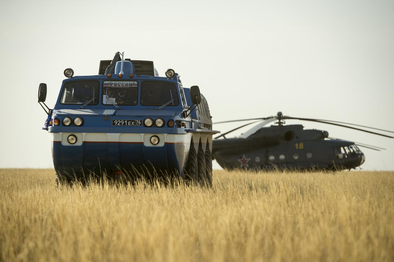 A Russian search and rescue all-terrain vehicle (ATV) and helicopter are seen at the landing site of the Soyuz TMA-08M spacecraft in a remote area near the town of Zhezkazgan, Kazakhstan, on Wednesday, Sept. 11, 2013. The Soyuz landed with Expedition 36 Commander Pavel Vinogradov of the Russian Federal Space Agency (Roscosmos), Flight Engineer Alexander Misurkin of Roscosmos and Flight Engineer Chris Cassidy. Vinogradov, Misurkin and Cassidy are returning to Earth after five and a half months on the International Space Station. Photo Credit: (NASA/Bill Ingalls)