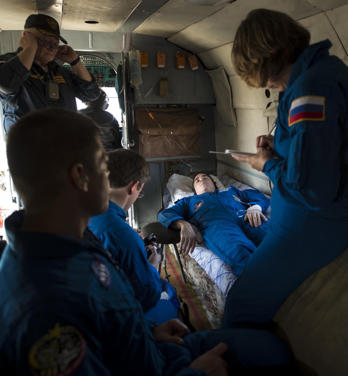 Expedition 36 Flight Engineer Chris Cassidy of NASA rest on a helicopter after he and, Commander Pavel Vinogradov of Russian Federal Space Agency (Roscosmos), and Flight Engineer Alexander Misurkin of Roscosmos landed in their Soyuz TMA-08M capsule in a remote area near the town of Zhezkazgan, Kazakhstan, on Wednesday, Sept. 11, 2013. Vinogradov, Misurkin and Cassidy returned to Earth after five and a half months on the International Space Station. Photo Credit: (NASA/Bill Ingalls)