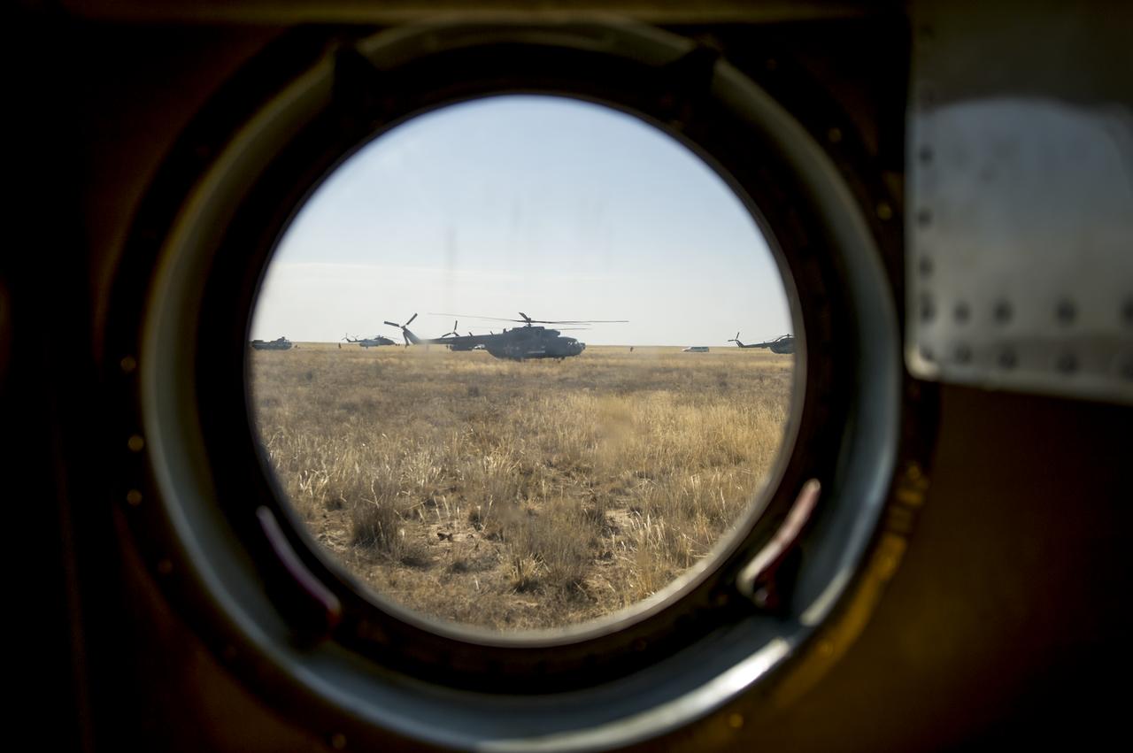 Russian search and rescue MI-8 helicopters are seen through the window of another helicopter at the landing site of the Soyuz TMA-08M spacecraft near the town of Zhezkazgan, Kazakhstan, on Wednesday, Sept. 11, 2013. The Soyuz landed with Expedition 36 Commander Pavel Vinogradov of the Russian Federal Space Agency (Roscosmos), Flight Engineer Alexander Misurkin of Roscosmos and Flight Engineer Chris Cassidy. Vinogradov, Misurkin and Cassidy are returning to Earth after five and a half months on the International Space Station. Photo Credit: (NASA/Bill Ingalls)