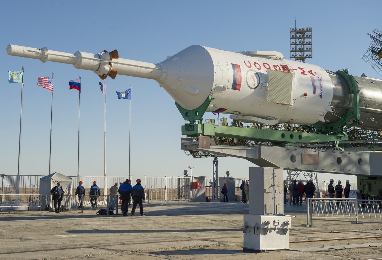 The Soyuz rocket is erected into position after being rolled out to the launch pad by train on Monday, Sept. 23, 2013, at the Baikonur Cosmodrome in Kazakhstan. Launch of the Soyuz rocket is scheduled for September 26 and will send Expedition 37 Soyuz Commander Oleg Kotov, NASA Flight Engineer Michael Hopkins and Russian Flight Engineer Sergei Ryazansky on a five and a half-month mission aboard the International Space Station.  Photo Credit: (NASA/Carla Cioffi)