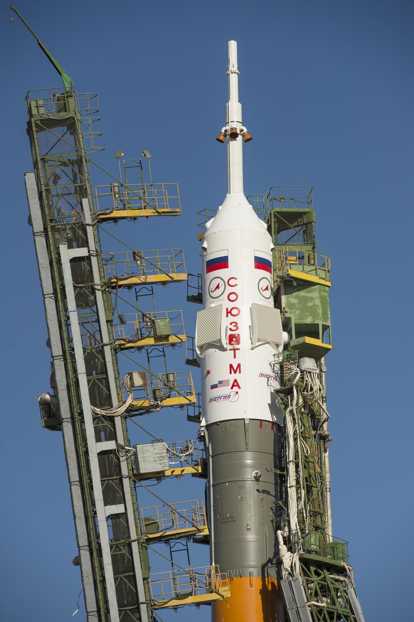 Large gantry mechanisms on either side of the Soyuz TMA-10M spacecraft are raised into position to secure the rocket at the launch pad on Monday, Sept. 23, 2013 at the Baikonur Cosmodrome in Kazakhstan. Launch of the Soyuz rocket is scheduled for September 26 and will send Expedition 37 Soyuz Commander Oleg Kotov, NASA Flight Engineer Michael Hopkins and Russian Flight Engineer Sergei Ryazansky on a five and a half-month mission aboard the International Space Station.  Photo Credit: (NASA/Carla Cioffi)
