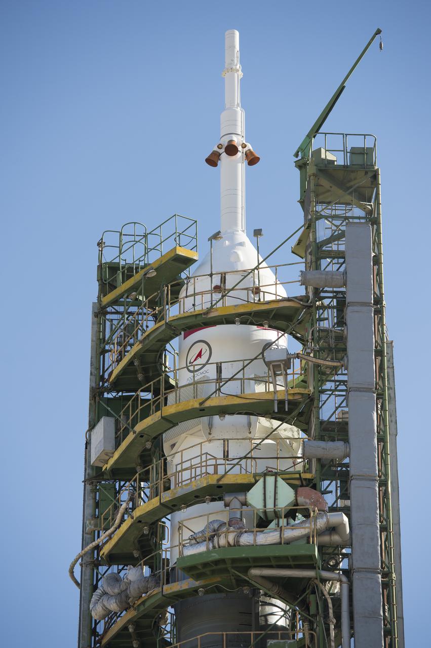 Large gantry mechanisms on either side of the Soyuz TMA-10M spacecraft are raised into position to secure the rocket at the launch pad on Monday, Sept. 23, 2013 at the Baikonur Cosmodrome in Kazakhstan. Launch of the Soyuz rocket is scheduled for September 26 and will send Expedition 37 Soyuz Commander Oleg Kotov, NASA Flight Engineer Michael Hopkins and Russian Flight Engineer Sergei Ryazansky on a five and a half-month mission aboard the International Space Station.  Photo Credit: (NASA/Carla Cioffi)