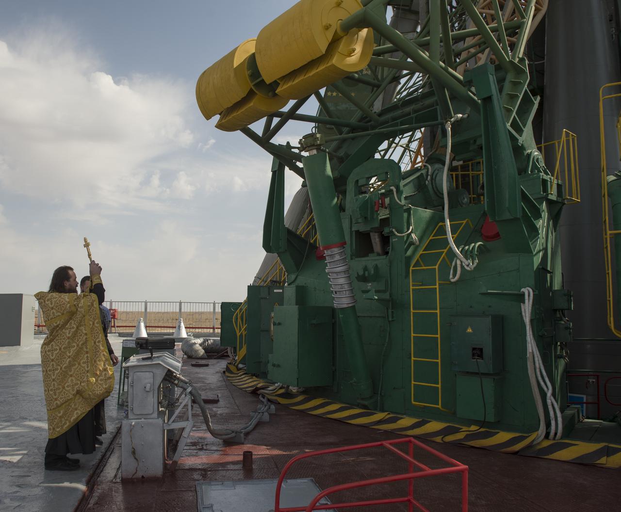 An Orthodox priest blesses the Soyuz rocket at the Baikonur Cosmodrome Launch pad on Tuesday, Sept. 24, 2013 in Baikonur, Kazakhstan. Launch of the Soyuz rocket is scheduled for September 26 and will send Expedition 37/38 Flight Engineer Michael Hopkins of NASA, Soyuz Commander Oleg Kotov and Flight Engineer and Russian Flight Engineer Sergei Ryazansky on a five-month mission aboard the International Space Station. Photo Credit: (NASA/Carla Cioffi)
