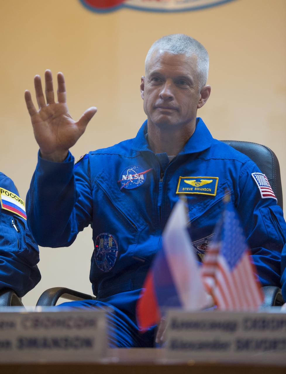 NASA backup crewmember Steve Swanson waves hello at a press conference held at the Cosmonaut Hotel, on Tuesday, Sept. 24, 2013, in Baikonur, Kazakhstan. Launch of the Soyuz rocket is scheduled for September 26 and will send Hopkins, Soyuz Commander Oleg Kotov and Russian Flight Engineer Sergei Ryazansky on a five and a half-month mission aboard the International Space Station.  Photo Credit: (NASA/Carla Cioffi)