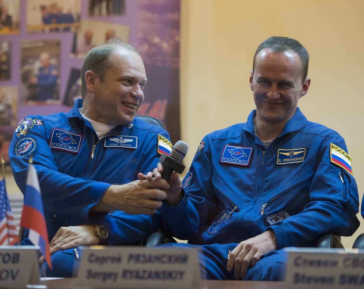 Expedition 37 Soyuz Commander Oleg Kotov, left, and Russian Flight Engineer Sergey Ryazanskiy  share a laugh at a press conference held at the Cosmonaut Hotel, on Tuesday, Sept. 24, 2013, in Baikonur, Kazakhstan. Launch of the Soyuz rocket is scheduled for September 26 and will send Kotov, Ryazanski and NASA Flight Engineer Michael Hopkins on a five and a half-month mission aboard the International Space Station.  Photo Credit: (NASA/Carla Cioffi)