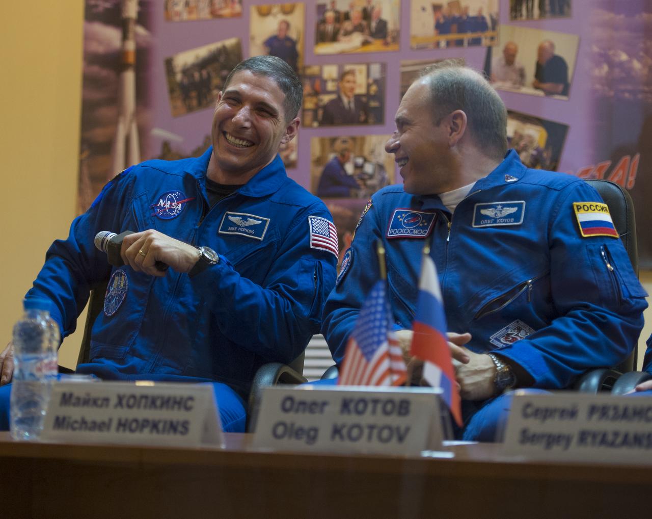 Expedition 37 NASA Flight Engineer Michael Hopkins, left, and Soyuz Commander Oleg Kotov share a laugh at a press conference held at the Cosmonaut Hotel, on Tuesday, Sept. 24, 2013, in Baikonur, Kazakhstan. Launch of the Soyuz rocket is scheduled for September 26 and will send Hopkins, Kotov and Russian Flight Engineer Sergei Ryazansky on a five and a half-month mission aboard the International Space Station.  Photo Credit: (NASA/Carla Cioffi)