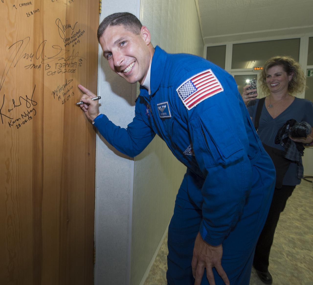 Expedition 37/38 NASA Flight Engineer Michael Hopkins performs the traditional door signing before he and fellow crewmates, Soyuz Commander Oleg Kotov, Russian Flight Engineer Sergey Ryazanskiy depart the Cosmonaut Hotel for their Soyuz launch to the International Space Station on Wednesday, Sept. 25, 2013, in Baikonur, Kazakhstan. Launch of the Soyuz rocket will send Hopkins, Kotov and Ryazanskiy on a five-month mission aboard the International Space Station.  Photo Credit: (NASA/Carla Cioffi)