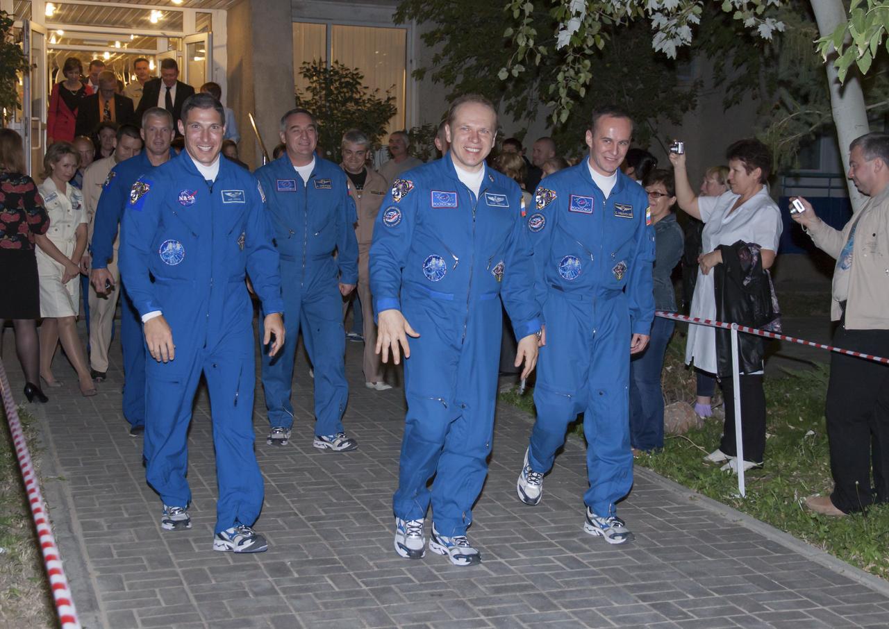 Expedition 37/38 crew members, Flight Engineer Michael Hopkins of NASA, left, Soyuz Commander Oleg Kotov of Roscosmos, and Russian Flight Engineer Sergey Ryazanskiy, right, depart the Cosmonaut Hotel to suit-up for their soyuz launch to the International Space Station on Wednesday, Wednesday, Sept. 25, 2013, in Baikonur, Kazakhstan. Launch of the Soyuz rocket will send Hopkins, Kotov and Ryazanskiy on a five-month mission aboard the International Space Station.  Photo Credit: (NASA/Carla Cioffi)