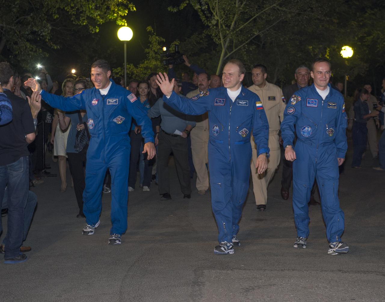 Expedition 37/38 crew members, Flight Engineer Michael Hopkins of NASA, left, Soyuz Commander Oleg Kotov of Roscosmos, and Russian Flight Engineer Sergey Ryazanskiy, right, wave farewell to family and friends as they depart the Cosmonaut Hotel to suit-up for their soyuz launch to the International Space Station on Wednesday, Wednesday, Sept. 25, 2013, in Baikonur, Kazakhstan. Launch of the Soyuz rocket will send Hopkins, Kotov and Ryazanskiy on a five-month mission aboard the International Space Station.  Photo Credit: (NASA/Carla Cioffi)