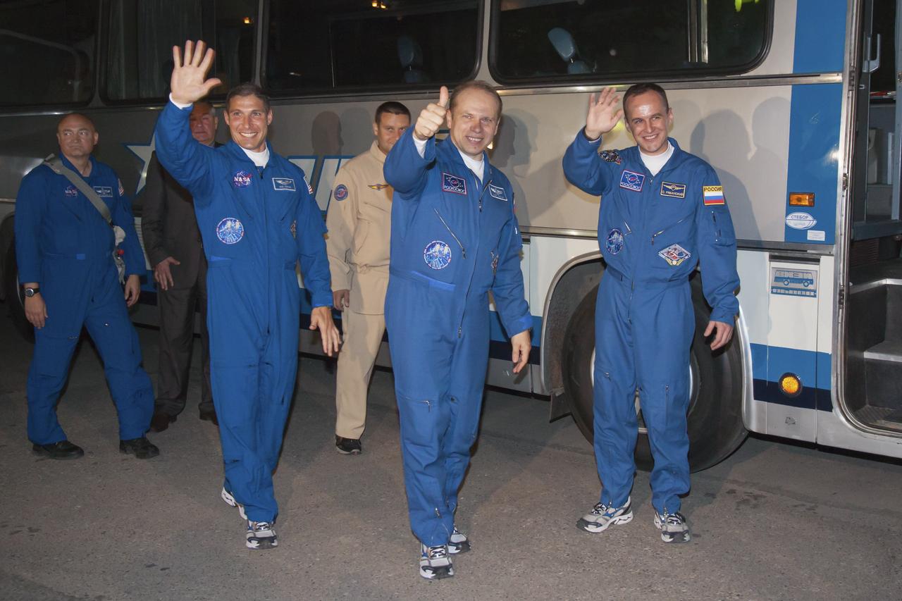 Expedition 37/38 crew members, Flight Engineer Michael Hopkins of NASA, left, Soyuz Commander Oleg Kotov of Roscosmos, and Russian Flight Engineer Sergey Ryazanskiy, right, wave farewell to family and friends as they depart the Cosmonaut Hotel to suit-up for their soyuz launch to the International Space Station on Wednesday, Wednesday, Sept. 25, 2013, in Baikonur, Kazakhstan. Launch of the Soyuz rocket will send Hopkins, Kotov and Ryazanskiy on a five-month mission aboard the International Space Station.  Photo Credit: (NASA/Victor Zelentsov)