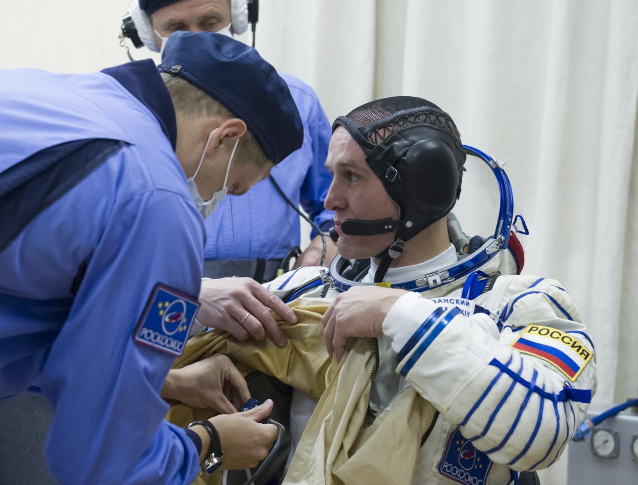 Expedition 37/38 Russian Flight Engineer Sergey Ryazanskiy is fitted into his Russian Sokol suit as he and fellow crewmates NASA Flight Engineer Michael Hopkins and Soyuz Commander Oleg Kotov prepare for their Soyuz launch to the International Space Station, on Wednesday, Sept. 25, 2013, in Baikonur, Kazakhstan. Launch of the Soyuz rocket will send Ryazanskiy, Hopkins and Kotov on a five-month mission aboard the International Space Station.  Photo Credit: (NASA/GCTC/Andrey Shelepin)