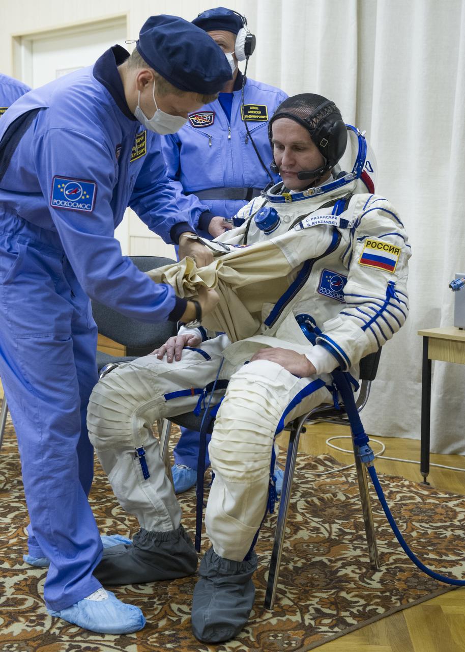 Expedition 37/38 Russian Flight Engineer Sergey Ryazanskiy is fitted into his Russian Sokol suit as he and fellow crewmates NASA Flight Engineer Michael Hopkins and Soyuz Commander Oleg Kotov prepare for their Soyuz launch to the International Space Station, on Wednesday, Sept. 25, 2013, in Baikonur, Kazakhstan. Launch of the Soyuz rocket will send Ryazanskiy, Hopkins and Kotov on a five-month mission aboard the International Space Station.  Photo Credit: (NASA/GCTC/Andrey Shelepin)