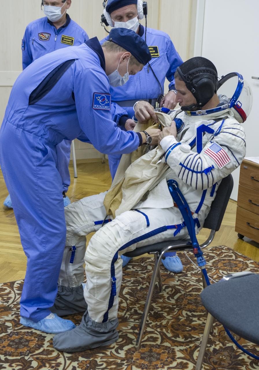 Expedition 37/38 NASA Flight Engineer Michael Hopkins is fitted into his Russian Sokol suit as he and fellow crewmates Soyuz Commander Oleg Kotov and Russian Flight Engineer Sergey Ryazanskiy prepare for their Soyuz launch to the International Space Station, on Wednesday, Sept. 25, 2013, in Baikonur, Kazakhstan. Launch of the Soyuz rocket will send Hopkins, Kotov and Ryazanskiy on a five-month mission aboard the International Space Station.  Photo Credit: (NASA/GCTC/Andrey Shelepin)
