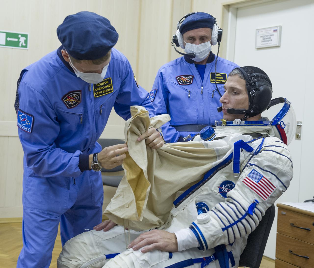 Expedition 37/38 NASA Flight Engineer Michael Hopkins is fitted into his Russian Sokol suit as he and fellow crewmates Soyuz Commander Oleg Kotov and Russian Flight Engineer Sergey Ryazanskiy prepare for their Soyuz launch to the International Space Station, on Wednesday, Sept. 25, 2013, in Baikonur, Kazakhstan. Launch of the Soyuz rocket will send Hopkins, Kotov and Ryazanskiy on a five-month mission aboard the International Space Station.  Photo Credit: (NASA/GCTC/Andrey Shelepin)