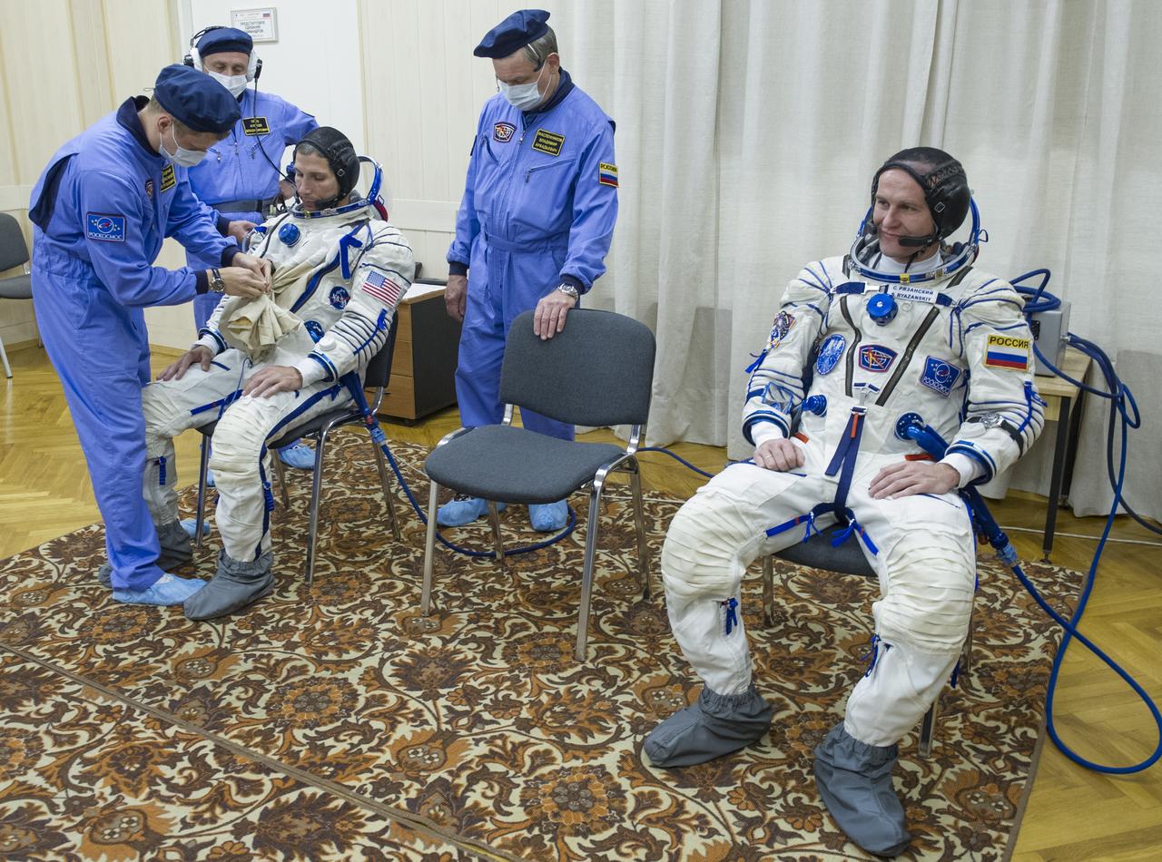 Expedition 37/38 NASA Flight Engineer Michael Hopkins, left, is fitted into his Russian Sokol suit as Russian Flight Engineer Sergey Ryazanskiy looks on, on Wednesday, Sept. 25, 2013, in Baikonur, Kazakhstan. Launch of the Soyuz rocket will send Hopkins, Kotov and Ryazanskiy on a five-month mission aboard the International Space Station.  Photo Credit: (NASA/GCTC/Andrey Shelepin)