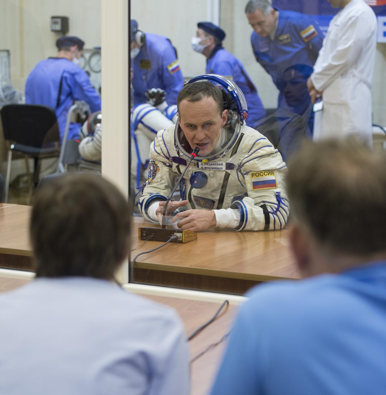 Expedition 37/38 Russian Flight Engineer Sergey Ryazanskiy is seen speaking to his family after having his Russian Sokol suit pressure checked ahead of his launch onboard a Soyuz TMA-10M spacecraft to the International Space Station, on Wednesday, Sept. 25, 2013, in Baikonur, Kazakhstan. Launch of the Soyuz rocket will send the Expedition 37/38 crewmates on a five-month mission aboard the International Space Station.  Photo Credit: (NASA/Carla Cioffi)