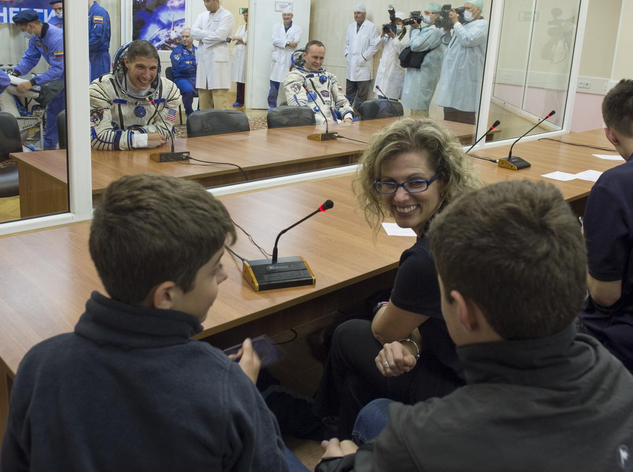 Expedition 37/38 NASA Engineer Michael Hopkins is seen speaking to his family after having his Russian Sokol suit pressure checked ahead of his launch onboard a Soyuz TMA-10M spacecraft to the International Space Station, on Wednesday, Sept. 25, 2013, in Baikonur, Kazakhstan. Launch of the Soyuz rocket will send the Expedition 37/38 crewmates on a five-month mission aboard the International Space Station.  Photo Credit: (NASA/Carla Cioffi)