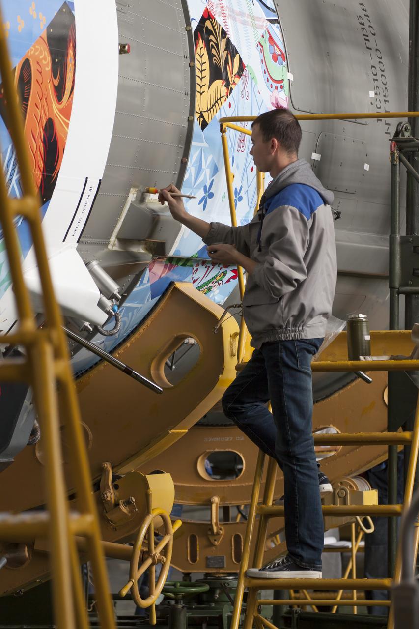 Workers make final preperations to a Soyuz TMA-11M spacecraft on Monday, Nov. 4, 2013, at the Baikonur Cosmodome in Baikonur, Kazakhstan. The rocket is adorned with the logo of the Sochi Olympic Organizing Committee and other related artwork to commemorate the launch of the Olympic torch with the crew for a four-day visit to the station. The torch will return to Earth with another trio of station residents on Nov. 11 and will be part of the torch relay that ends with the lighting of the flame at the Fisht Stadium in Sochi, Russia Feb. 7 to mark the opening of the 2014 Winter Olympics. Photo Credit: (NASA/Victor Zelentsov)