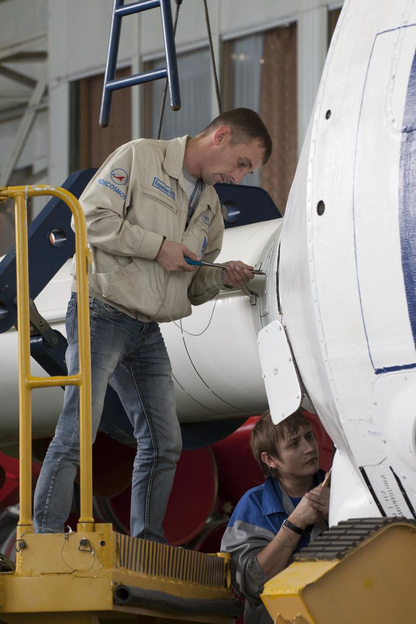 Workers make final preperations to a Soyuz TMA-11M spacecraft on Monday, Nov. 4, 2013, at the Baikonur Cosmodome in Baikonur, Kazakhstan. The rocket is adorned with the logo of the Sochi Olympic Organizing Committee and other related artwork to commemorate the launch of the Olympic torch with the crew for a four-day visit to the station. The torch will return to Earth with another trio of station residents on Nov. 11 and will be part of the torch relay that ends with the lighting of the flame at the Fisht Stadium in Sochi, Russia Feb. 7 to mark the opening of the 2014 Winter Olympics. Photo Credit: (NASA/Victor Zelentsov)