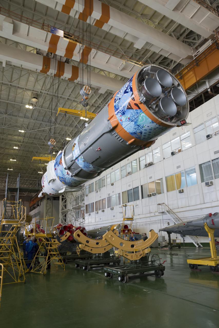 Workers make final preperations to a Soyuz TMA-11M spacecraft on Monday, Nov. 4, 2013, at the Baikonur Cosmodome in Baikonur, Kazakhstan. The rocket is adorned with the logo of the Sochi Olympic Organizing Committee and other related artwork to commemorate the launch of the Olympic torch with the crew for a four-day visit to the station. The torch will return to Earth with another trio of station residents on Nov. 11 and will be part of the torch relay that ends with the lighting of the flame at the Fisht Stadium in Sochi, Russia Feb. 7 to mark the opening of the 2014 Winter Olympics. Photo Credit: (NASA/Victor Zelentsov)