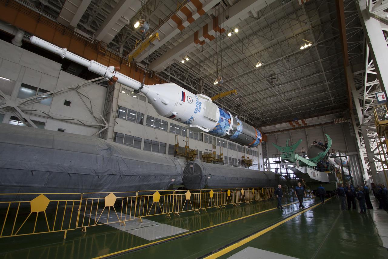 Workers make final preperations to a Soyuz TMA-11M spacecraft on Monday, Nov. 4, 2013, at the Baikonur Cosmodome in Baikonur, Kazakhstan. The rocket is adorned with the logo of the Sochi Olympic Organizing Committee and other related artwork to commemorate the launch of the Olympic torch with the crew for a four-day visit to the station. The torch will return to Earth with another trio of station residents on Nov. 11 and will be part of the torch relay that ends with the lighting of the flame at the Fisht Stadium in Sochi, Russia Feb. 7 to mark the opening of the 2014 Winter Olympics. Photo Credit: (NASA/Victor Zelentsov)