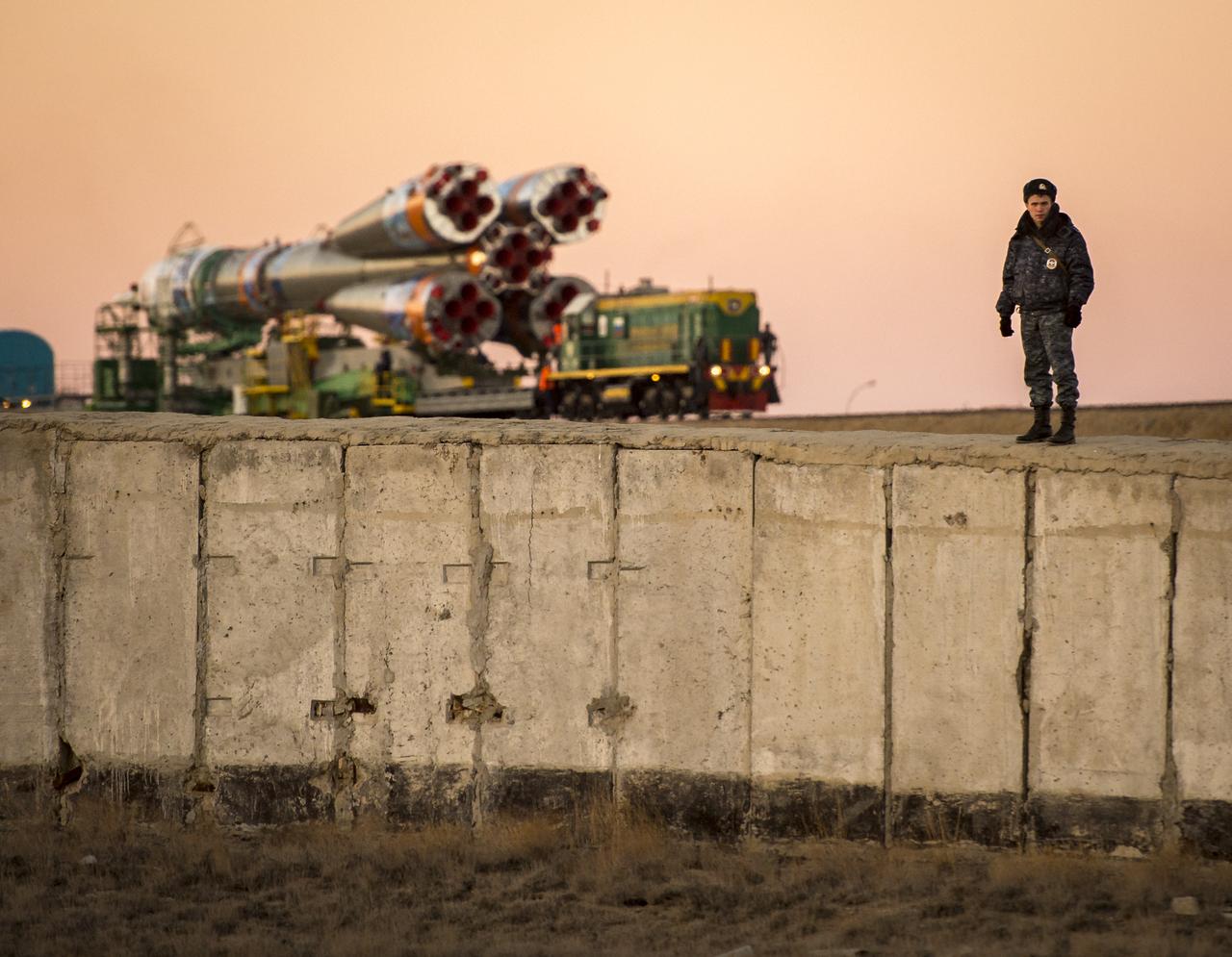 Security monitors the Soyuz TMA-11M rocket as it is rolled out to the launch pad by train on Tuesday, Nov. 5, 2013, at the Baikonur Cosmodrome in Kazakhstan. Launch of the Soyuz rocket is scheduled for November 7 and will send Expedition 38 Soyuz Commander Mikhail Tyurin of Roscosmos, Flight Engineer Rick Mastracchio of NASA and Flight Engineer Koichi Wakata of the Japan Aerospace Exploration Agency on a six-month mission aboard the International Space Station. Photo Credit: (NASA/Bill Ingalls)