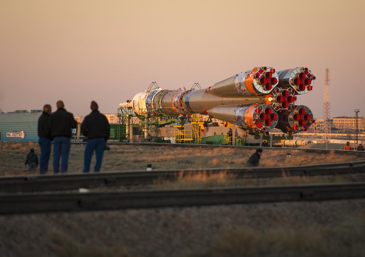 The three Expedition 38/39 backup crew members, left,  watch as the Soyuz TMA-11M rocket is rolled out to the launch pad by train on Tuesday, Nov. 5, 2013, at the Baikonur Cosmodrome in Kazakhstan. Launch of the Soyuz rocket is scheduled for November 7 and will send Expedition 38 Soyuz Commander Mikhail Tyurin of Roscosmos, Flight Engineer Rick Mastracchio of NASA and Flight Engineer Koichi Wakata of the Japan Aerospace Exploration Agency on a six-month mission aboard the International Space Station.  Photo Credit: (NASA/Bill Ingalls)