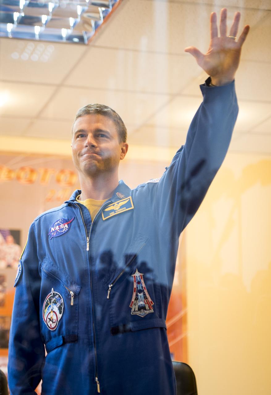 Expedition 38 backup crew member Reid Wiseman of NASA is seen in quarantine, behind glass, during the final press conference held a day ahead of the launch of Expedition 38 prime crew members; Flight Engineer Koichi Wakata of the Japan Aerospace Exploration Agency, Soyuz Commander Mikhail Tyurin of Roscosmos, and, Flight Engineer Rick Mastracchio of NASA, to the International Space Station, Wednesday, Nov. 6, 2013 at the Cosmonaut Hotel in Baikonur, Kazakhstan.  Photo Credit: (NASA/Bill Ingalls)