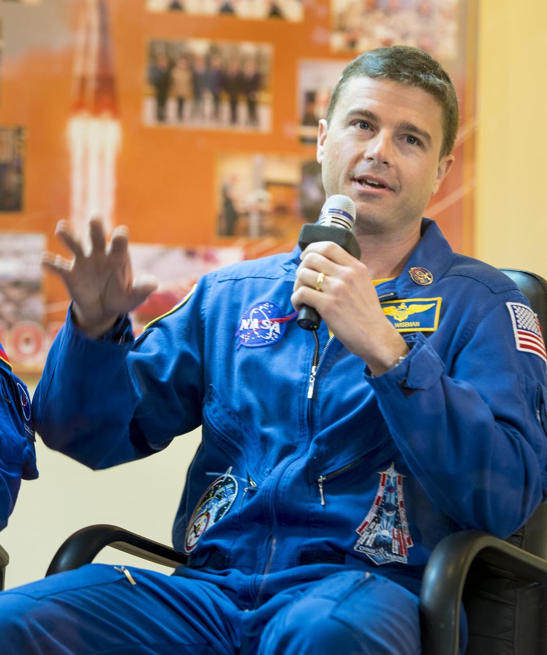 Expedition 38 backup crew member Reid Wiseman of NASA is seen in quarantine, behind glass, during the final press conference held a day ahead of the launch of Expedition 38 prime crew members; Flight Engineer Koichi Wakata of the Japan Aerospace Exploration Agency, Soyuz Commander Mikhail Tyurin of Roscosmos, and, Flight Engineer Rick Mastracchio of NASA, to the International Space Station, Wednesday, Nov. 6, 2013 at the Cosmonaut Hotel in Baikonur, Kazakhstan.  Photo Credit: (NASA/Bill Ingalls)