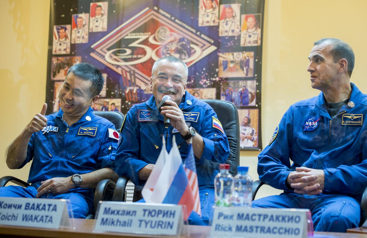 Expedition 38 Soyuz Commander Mikhail Tyurin of Roscosmos, center, talks as Flight Engineer Koichi Wakata of the Japan Aerospace Exploration Agency, left, and, Flight Engineer Rick Mastracchio of NASA listen, while quarantine behind glass, during the final press conference held a day ahead of their launch to the International Space Station, Wednesday, Nov. 6, 2013 at the Cosmonaut Hotel in Baikonur, Kazakhstan.  Photo Credit: (NASA/Bill Ingalls)