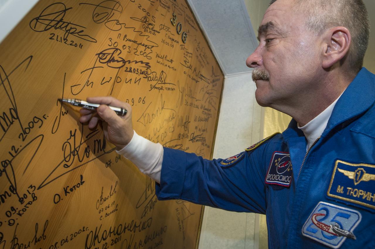 Expedition 38 Soyuz Commander Mikhail Tyurin of Roscosmos, performs the traditional door signing at the Cosmonaut hotel prior to departing the hotel for launch in a Soyuz rocket with fellow crew mates, Flight Engineer Koichi Wakata of the Japan Aerospace Exploration Agency, and, Flight Engineer Rick Mastracchio of NASA, Thursday, Nov. 7, 2013, in Baikonur, Kazakhstan. Tyurin, Wakata, and, Mastracchio will launch in their Soyuz TMA-11M spacecraft to the International Space Station to begin a six-month mission. Photo Credit (NASA/Bill Ingalls)