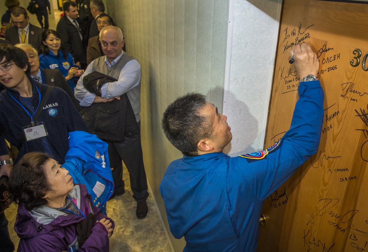 Expedition 38 Flight Engineer Koichi Wakata of the Japan Aerospace Exploration Agency, performs the traditional door signing at the Cosmonaut hotel prior to departing the hotel for launch in a Soyuz rocket with fellow crew mates, Soyuz Commander Mikhail Tyurin of Roscosmos, and, Flight Engineer Rick Mastracchio of NASA, Thursday, Nov. 7, 2013, in Baikonur, Kazakhstan. Tyurin, Wakata, and, Mastracchio will launch in their Soyuz TMA-11M spacecraft to the International Space Station to begin a six-month mission. Photo Credit (NASA/Bill Ingalls)