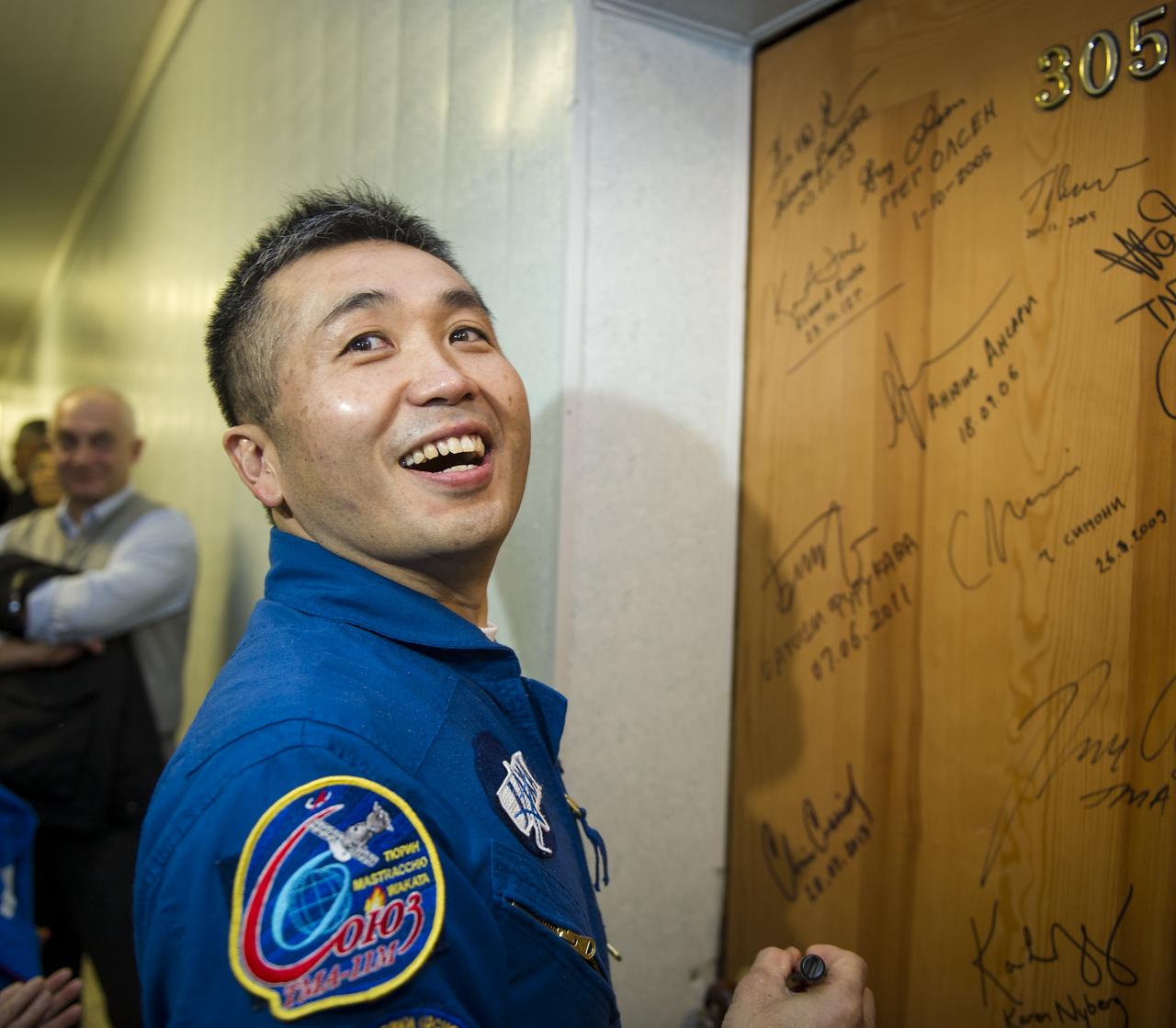 Expedition 38 Flight Engineer Koichi Wakata of the Japan Aerospace Exploration Agency, performs the traditional door signing at the Cosmonaut hotel prior to departing the hotel for launch in a Soyuz rocket with fellow crew mates, Soyuz Commander Mikhail Tyurin of Roscosmos, and, Flight Engineer Rick Mastracchio of NASA, Thursday, Nov. 7, 2013, in Baikonur, Kazakhstan. Tyurin, Wakata, and, Mastracchio will launch in their Soyuz TMA-11M spacecraft to the International Space Station to begin a six-month mission. Photo Credit: (NASA/GCTC/Irina Peshkova)