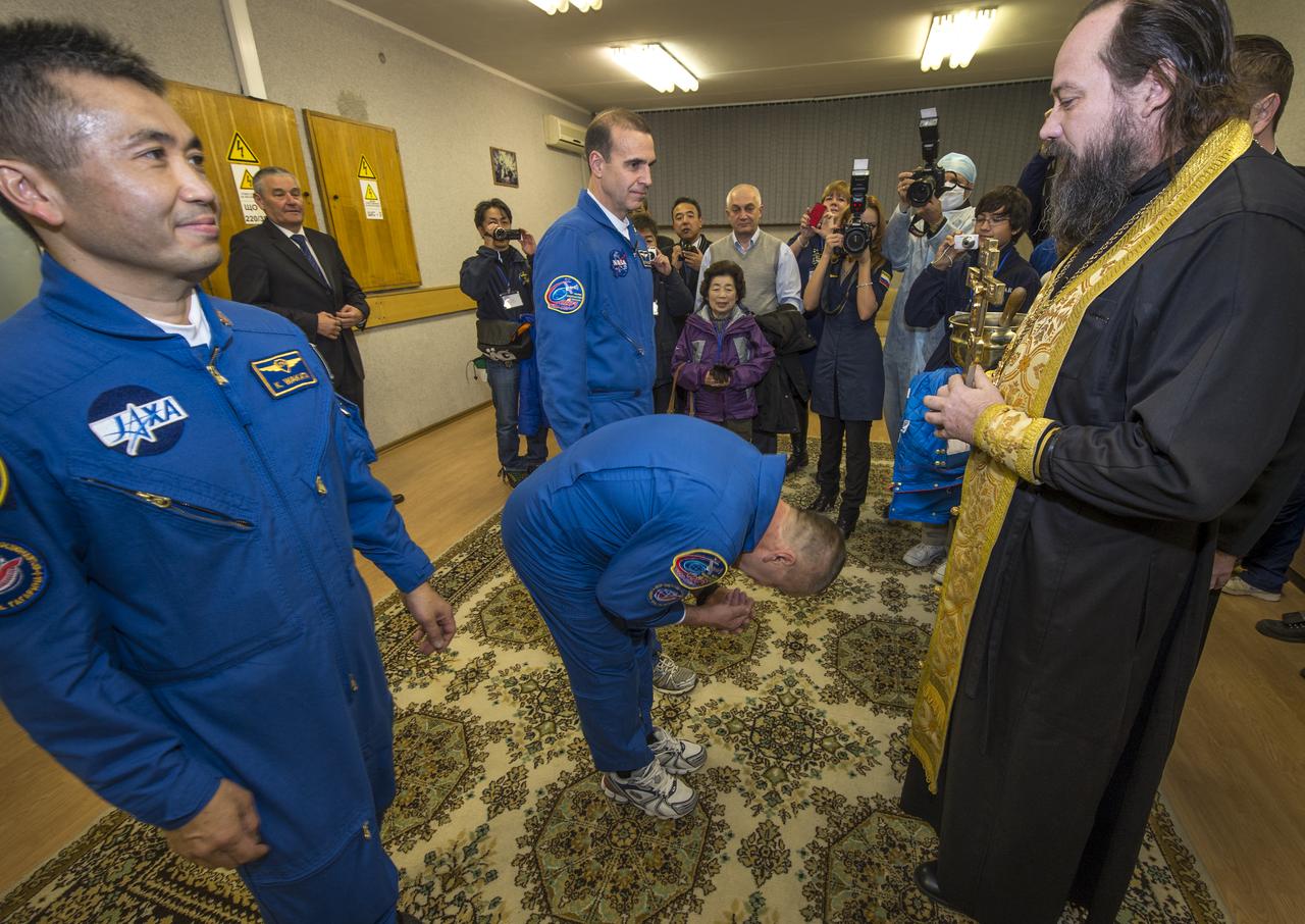 Expedition 38 Flight Engineer Koichi Wakata of the Japan Aerospace Exploration Agency, left, Soyuz Commander Mikhail Tyurin of Roscosmos, 2nd from left, and, Flight Engineer Rick Mastracchio of NASA, prepare to receive the traditional blessing from a Russian Orthodox priest at the Cosmonaut Hotel prior to their launch on the Soyuz rocket to the International Space Station, Thursday, Nov. 7, 2013, in Baikonur, Kazakhstan. Tyurin, Wakata, and, Mastracchio will launch in their Soyuz TMA-11M spacecraft to the International Space Station to begin a six-month mission. Photo Credit (NASA/Bill Ingalls)