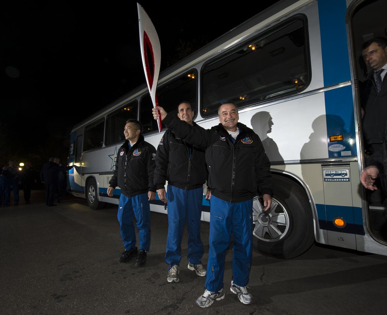 Expedition 38 Flight Engineer Koichi Wakata of the Japan Aerospace Exploration Agency, left, Flight Engineer Rick Mastracchio of NASA, and, Soyuz Commander Mikhail Tyurin of Roscosmos, right, are seen as they depart the Cosmonaut hotel with the Olympic Torch that will be launched with them on the Soyuz rocket to the International Space Station, Thursday, Nov. 7, 2013, in Baikonur, Kazakhstan. The Olympic torch will have a four-day visit to station and will return to Earth with another trio of station residents on Nov. 11 and will be part of the torch relay that ends with the lighting of the flame at the Fisht Stadium in Sochi, Russia Feb. 7 to mark the opening of the 2014 Winter Olympics. Photo Credit: (NASA/Bill Ingalls)