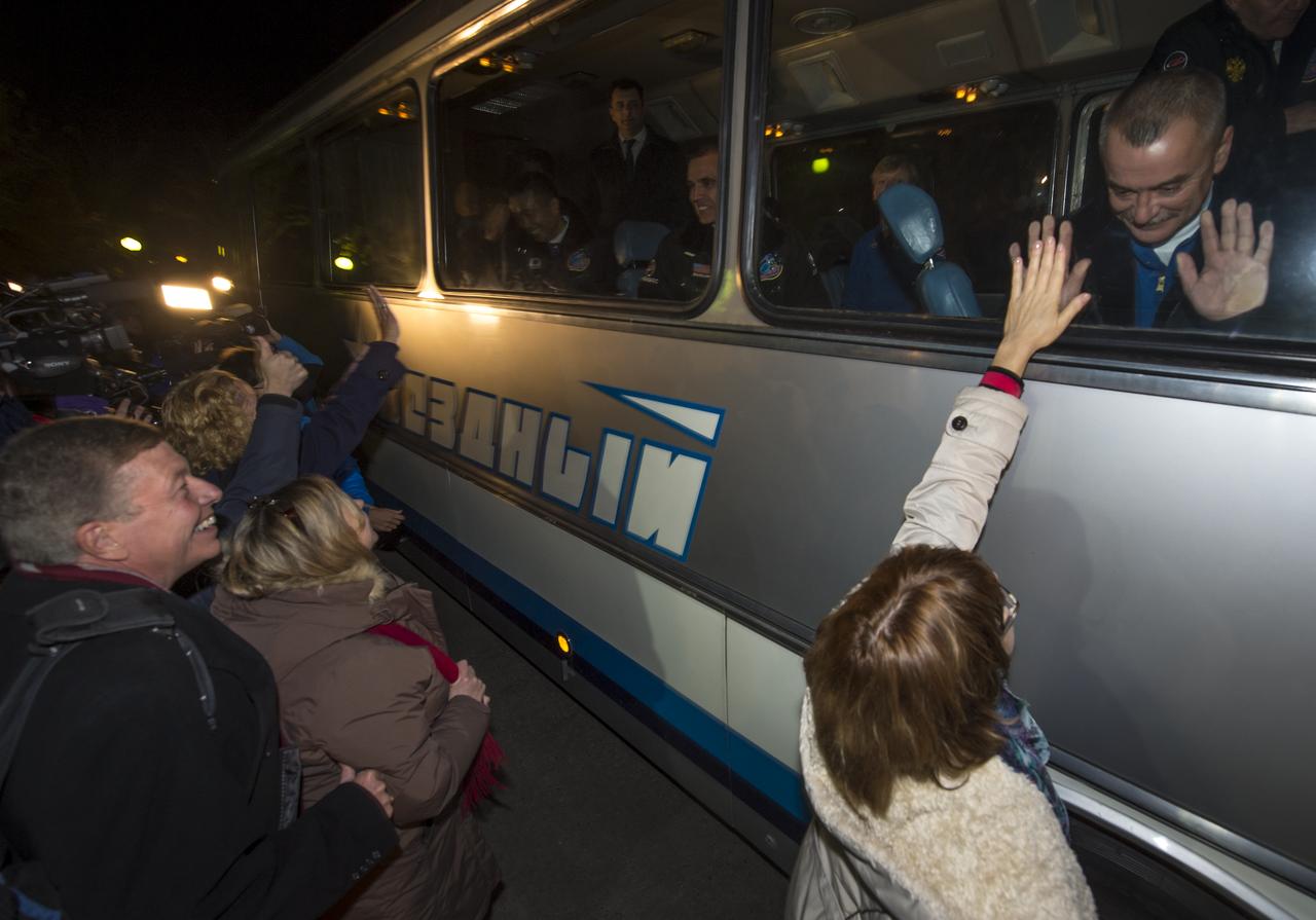Expedition 38 Flight Engineer Koichi Wakata of the Japan Aerospace Exploration Agency, on bus left, Flight Engineer Rick Mastracchio of NASA, and, Soyuz Commander Mikhail Tyurin of Roscosmos, right, wave farewell to friends and family as they depart the Cosmonaut hotel ahead of their launch on a Soyuz rocket to the International Space Station, Thursday, Nov. 7, 2013, in Baikonur, Kazakhstan. Photo Credit: (NASA/Bill Ingalls)