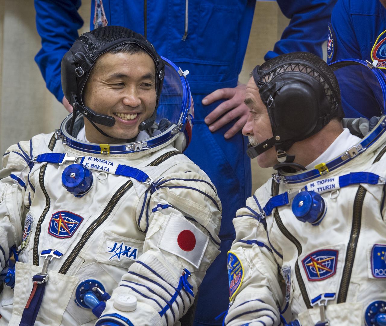 Expedition 38 Flight Engineer Koichi Wakata of the Japan Aerospace Exploration Agency, left, and, Soyuz Commander Mikhail Tyurin of Roscosmos are seen through glass as they and fellow crew mate,  Flight Engineer Rick Mastracchio of NASA, have their Russian Sokol suits pressure checked a few hours ahead of their launch, Thursday, Nov. 7, 2013, in Baikonur, Kazakhstan. Tyurin, Wakata, and, Mastracchio will launch in their Soyuz TMA-11M spacecraft to the International Space Station to begin a six-month mission. Photo Credit (NASA/Bill Ingalls)