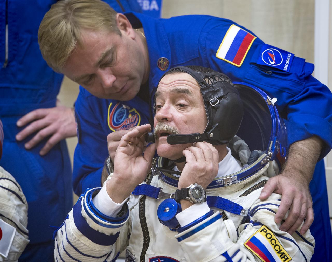 Expedition 38 Soyuz Commander Mikhail Tyurin of Roscosmos, seated, and backup crew member Russian cosmonaut Max Suraev, are seen through glass as Tyurin and fellow crew mates, Flight Engineer Koichi Wakata of the Japan Aerospace Exploration Agency, and, Flight Engineer Rick Mastracchio of NASA, have their Russian Sokol suits pressure checked a few hours ahead of their launch, Thursday, Nov. 7, 2013, in Baikonur, Kazakhstan. Tyurin, Wakata, and, Mastracchio will launch in their Soyuz TMA-11M spacecraft to the International Space Station to begin a six-month mission. Photo Credit (NASA/Bill Ingalls)