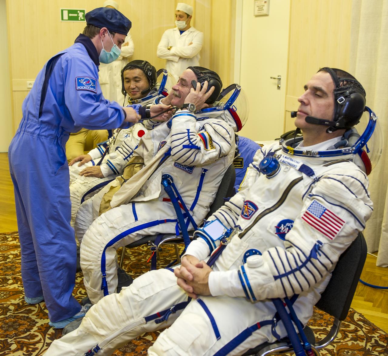 From left, Expedition 38 Flight Engineer Koichi Wakata of the Japan Aerospace Exploration Agency, Soyuz Commander Mikhail Tyurin of Roscosmos, and, Flight Engineer Rick Mastracchio of NASA don their Russian sokol suits a few hours ahead of their launch on a soyuz rocket, Thursday, Nov. 7, 2013, in Baikonur, Kazakhstan. Tyurin, Wakata, and, Mastracchio will launch in their Soyuz TMA-11M spacecraft to the International Space Station to begin a six-month mission. Photo Credit: (NASA/GCTC/Irina Peshkova)