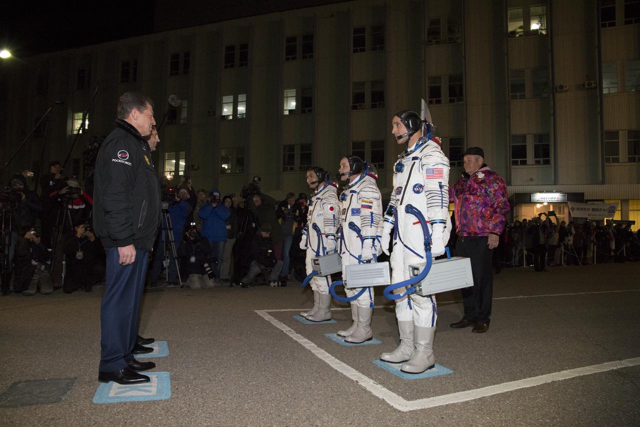 Dmitry Kozak, Deputy Prime Minister of Russian Federation, standing left, next to, Oleg Ostapenko, Head of Roscosmos, give a formal farewell to Expedition 38 Flight Engineer Koichi Wakata of the Japan Aerospace Exploration Agency, far right, Soyuz Commander Mikhail Tyurin of Roscosmos, center, and, Flight Engineer Rick Mastracchio of NASA, as Division Chief, GCTC, Valery Korzun holds the Olympic torch that will travel with the crew on their soyuz TMA-11M rocket to the International Space Station, Thursday, Nov. 7, 2013, in Baikonur, Kazakhstan. Photo Credit: (NASA/Victor Zelentsov)