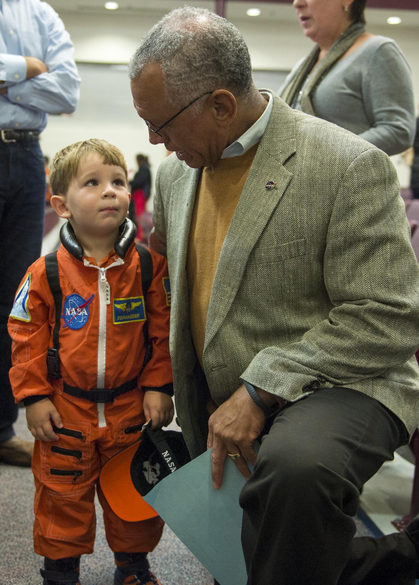 NASA Administrator Charles F. Bolden greets a young boy in an astronaut suit during a stargazing event on Thursday, Nov. 7, 2013