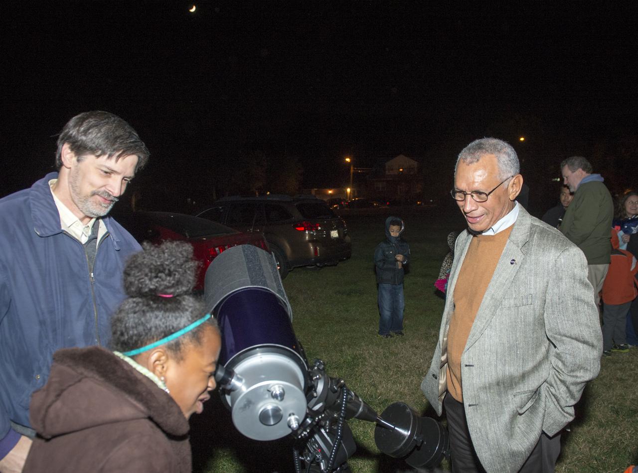 NASA Administrator Charles F. Bolden looks on as Kalani Brown, 9, of Arlington, Va., looks at the moon through a telescope during a stargazing event at Hoffman-Boston Elementary School in Arlington, Va. on Thursday, Nov. 7, 2013. Photo Credit: (NASA/Jay Westcott)