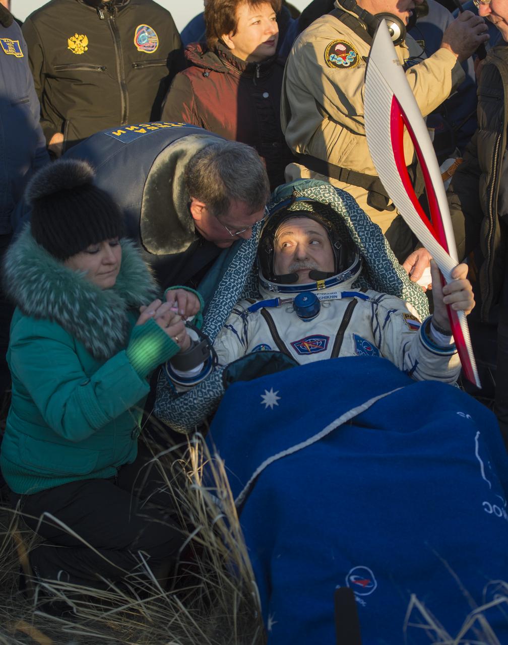 Expedition 37 Commander Fyodor Yurchikhin is seen holding the Olympic torch minutes after he and his crew landed in a remote area southeast of the town of Zhezkazgan, Kazakhstan, on Monday, Nov. 11, 2013. The Olympic torch was launched with the crew of Expedition 38 to the International Space Station on November 7. It was passed from one module to the next and had its first spacewalk on November 9 with two Russian cosmonauts as part of its international relay. Now back on earth it will continue its journey to Sochi, Russia for the 2014 Winter Games. Photo Credit: (NASA/Carla Cioffi)